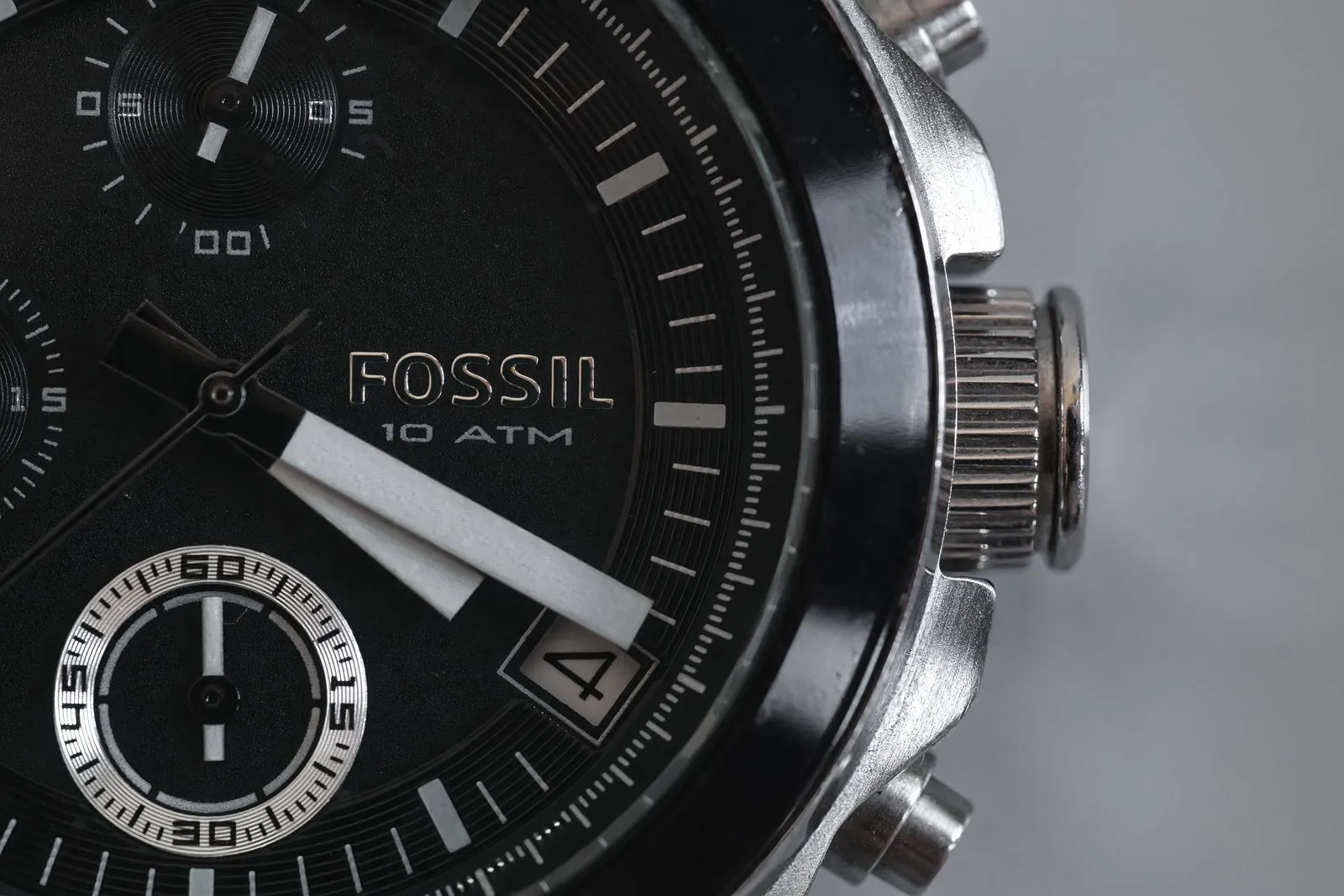 Detailed close-up of a Fossil wristwatch face with visible chronograph and date features.